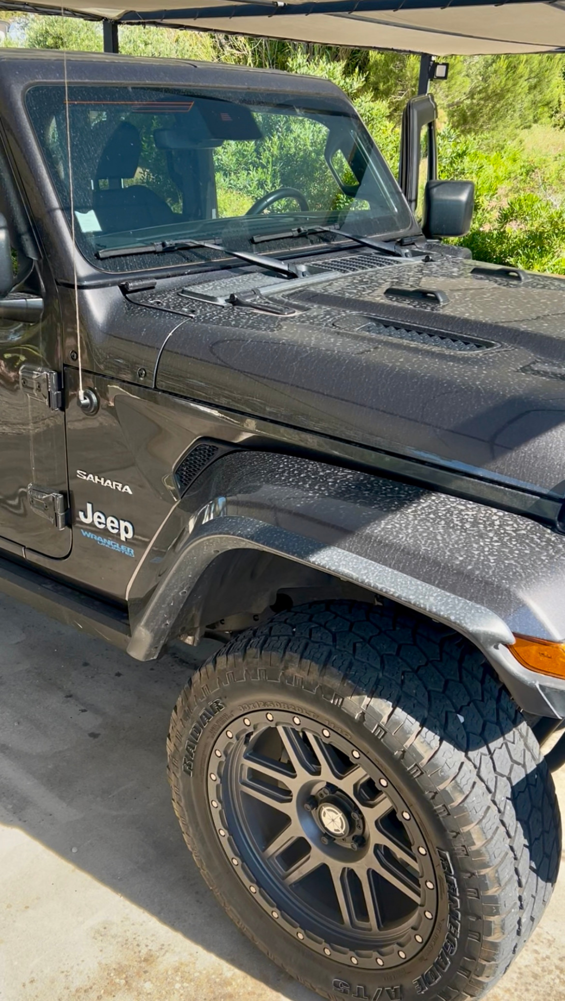 Véhicule tout-terrain noir avec des roues surdimensionnées et un design robuste.